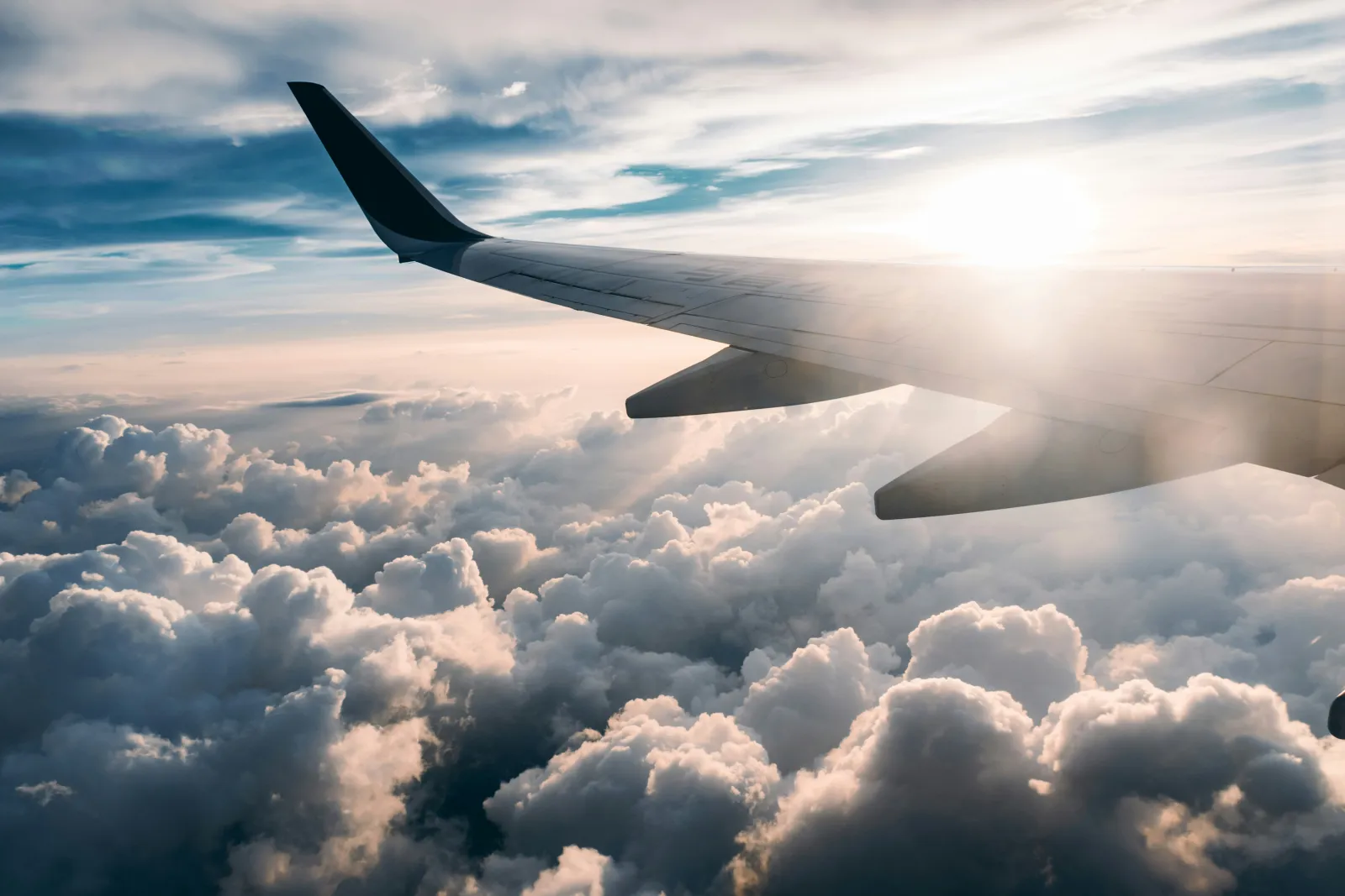 Aereo sopra le nuvole in volo verso destinazioni internazionali per viaggi e vacanze nel mondo