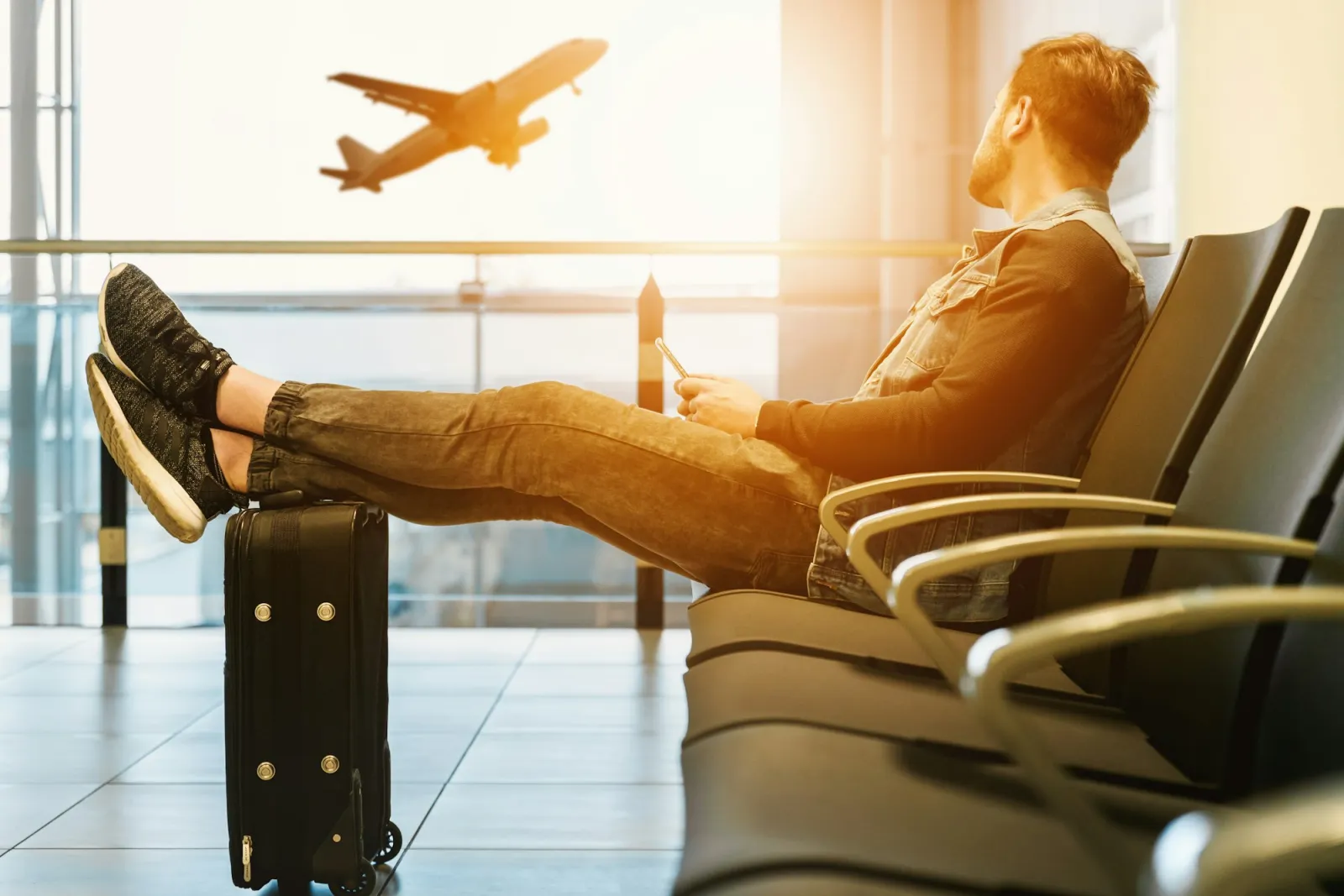 Persona in attesa del volo in aeroporto nella zona partenze prima di un viaggio