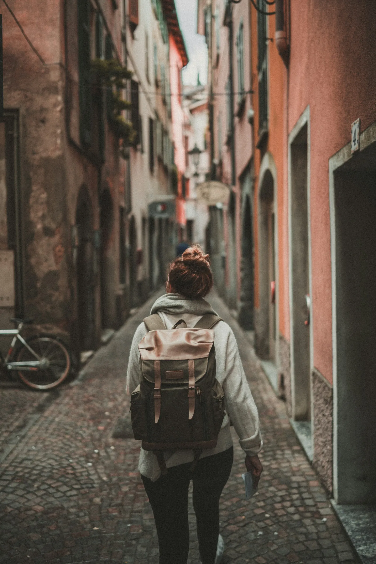 Donna turista che visita una città storica europea tra edifici antichi e strade caratteristiche